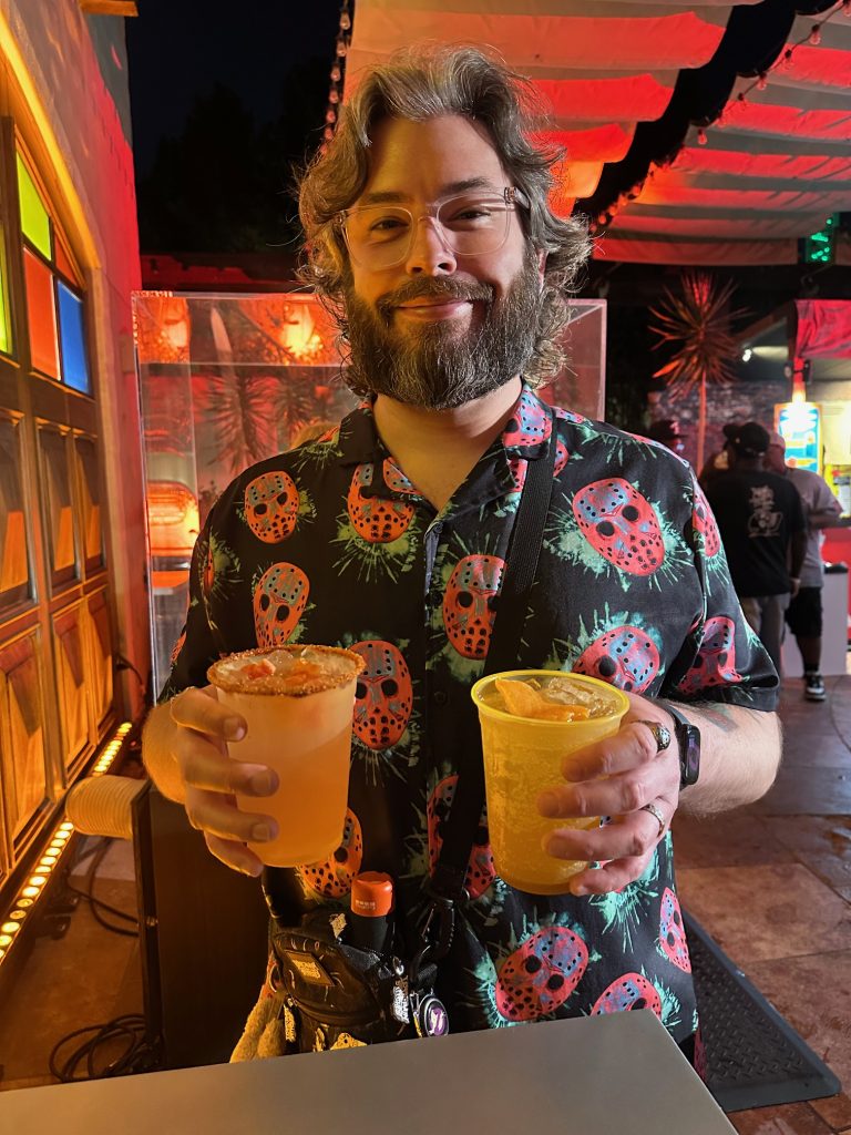 man holding 2 cocktails at the Chucky Dive Bar