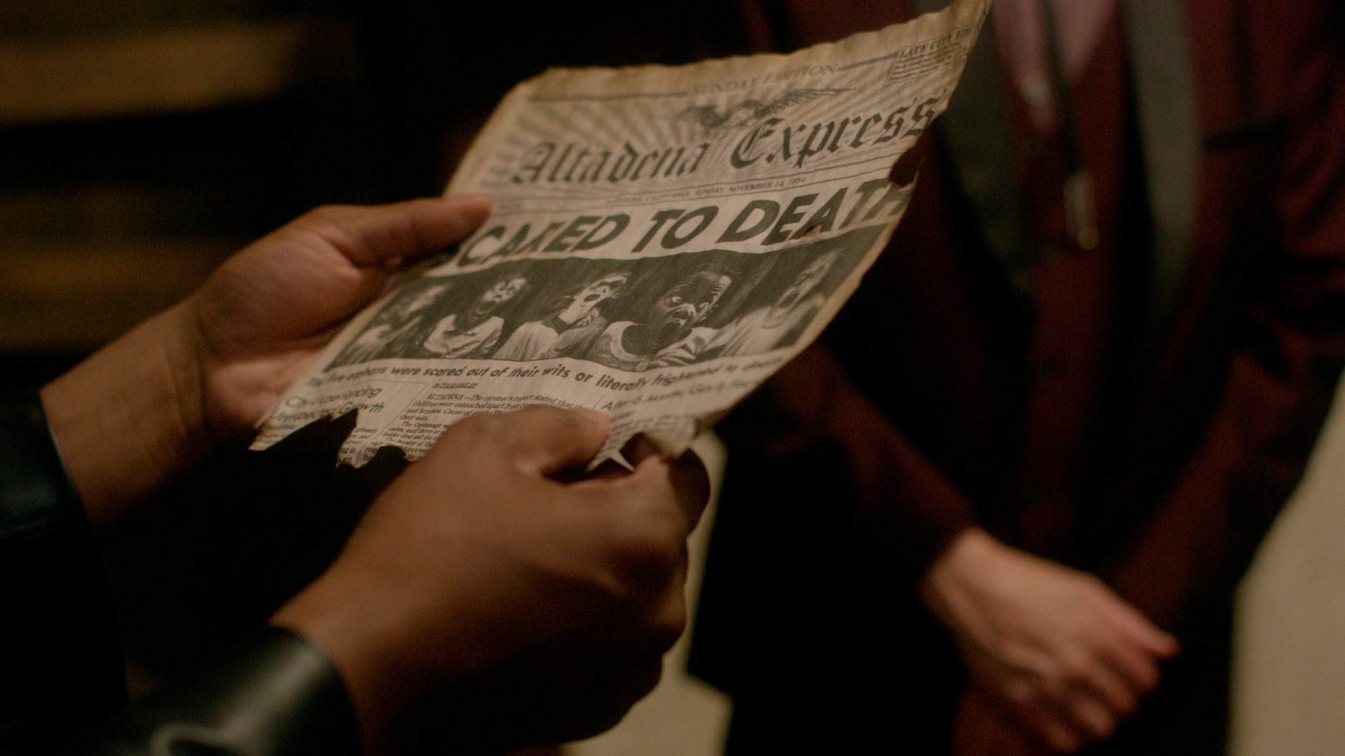 movie still from Scared to Death depicting someone holding a newspaper with the headline 'Scared to Death'