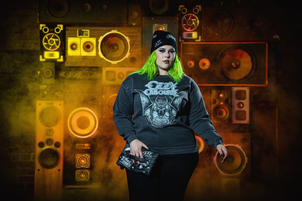 model with bright green hair sporting Ozzy Osbourne sweatshirt, purse and beanie